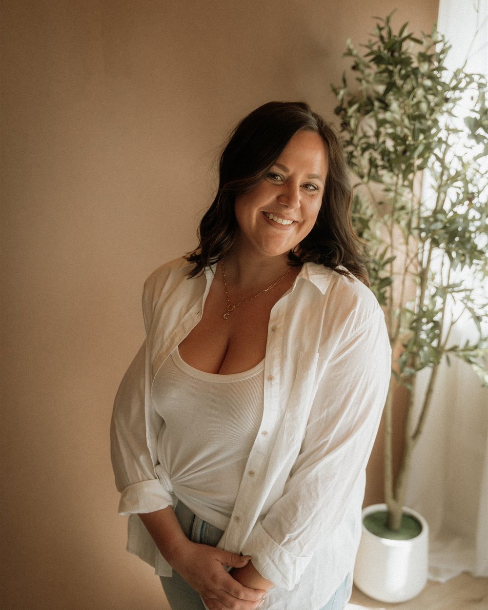 Cydnie Brown, founder of Jocelyn & Co. Travel, smiling in a white shirt.