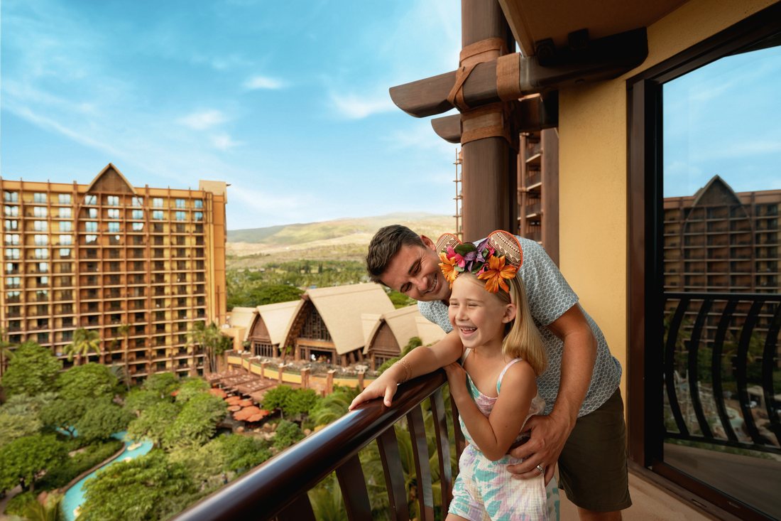 A family on a room balcony overlooking the resort at AULANI.