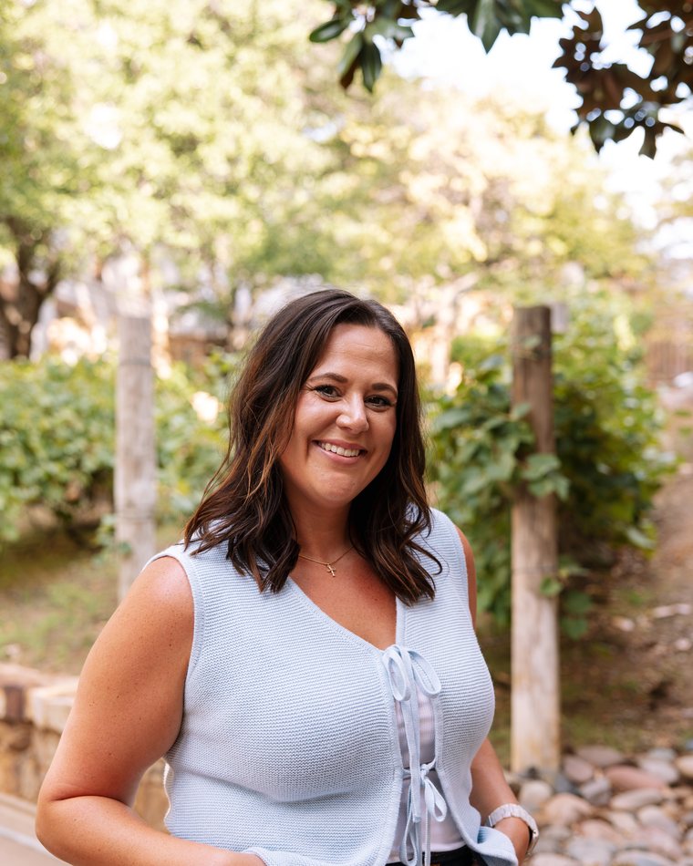 Cydnie Brown smiling outdoors in a light blue top.