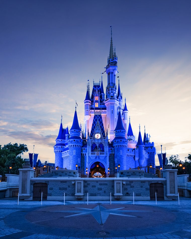 Cinderella Castle lit in blue at dusk at Magic Kingdom Park.
