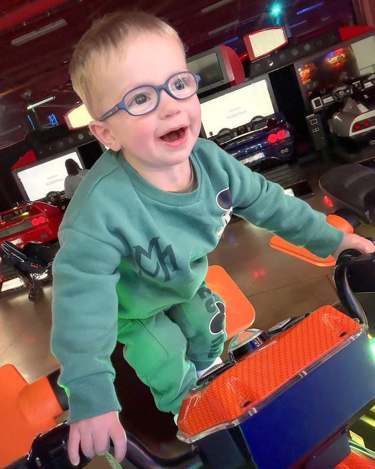 Cydnie's son grinning on an arcade ride.