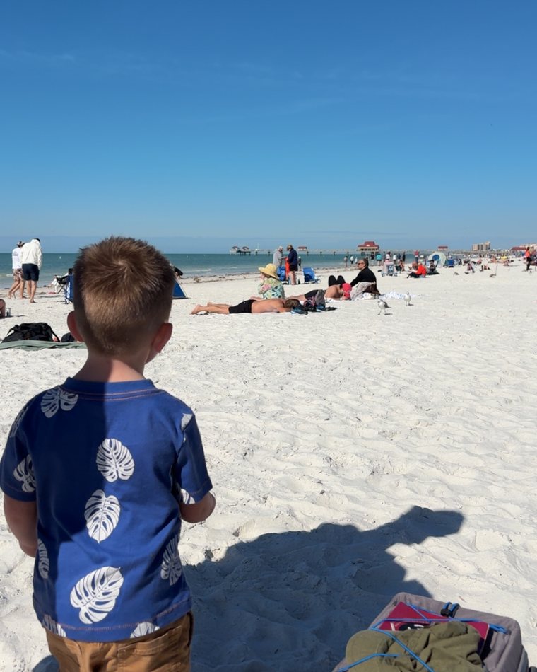 Cydnie's son looking out at a white sand beach.