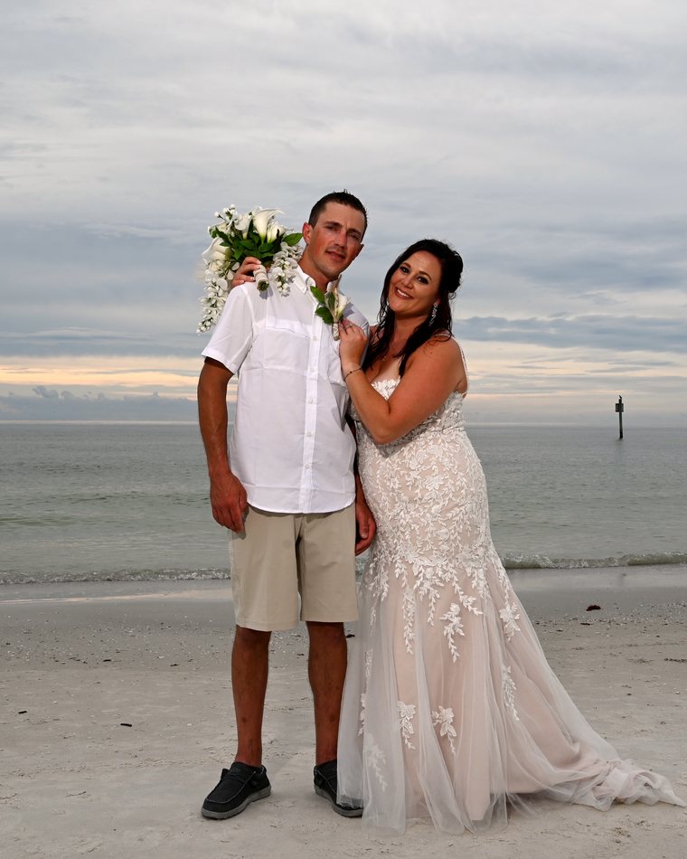 Cydnie and her husband smiling together on the beach on their wedding day.